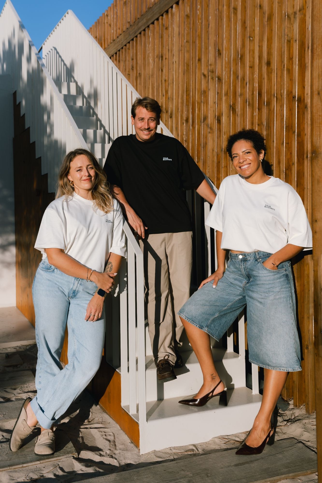 Trois membres de l'équipe Bluecoders sur un escalier extérieur